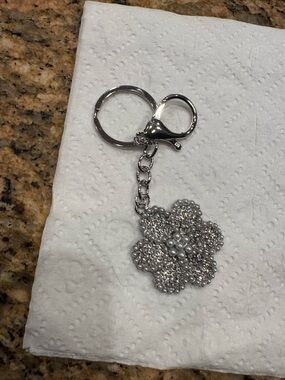flower-shaped keychain or bag charm decorated with crystals and faux pearls